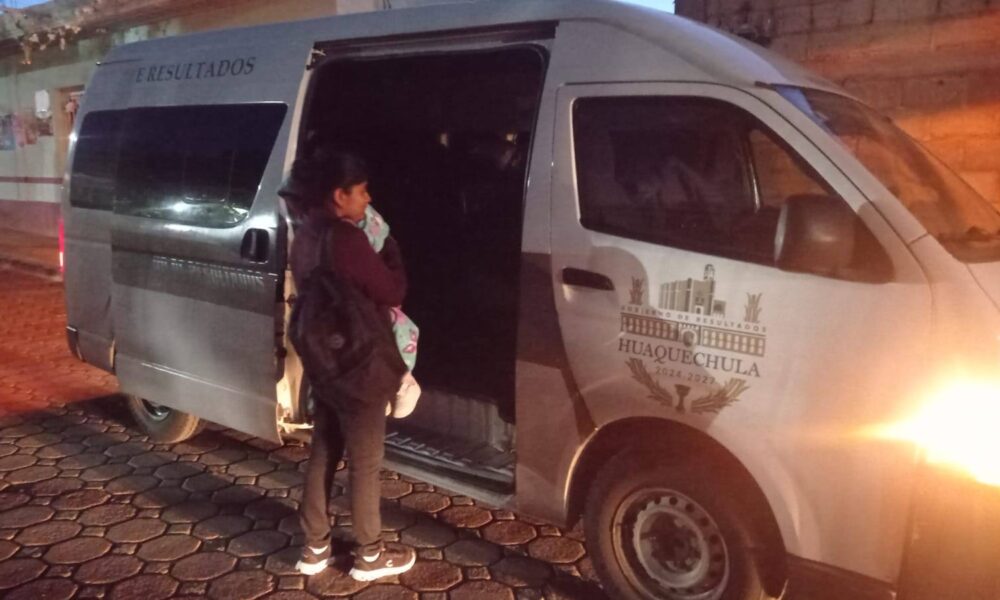 Mujer con un bebé en brazos aborda una camioneta oficial del Ayuntamiento de Huaquechula 2024-2027 durante la madrugada, como parte del programa gratuito de traslados médicos a hospitales de Puebla y Ciudad de México.