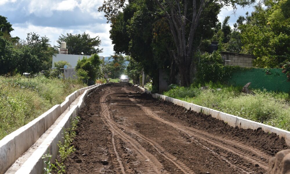 Camino en construcción en la comunidad de Cacaloxúchitl, Huaquechula. La calle 2 Oriente muestra avances en su preparación para ser adoquinada, con muros laterales terminados y la superficie lista para recibir el material de pavimentación.