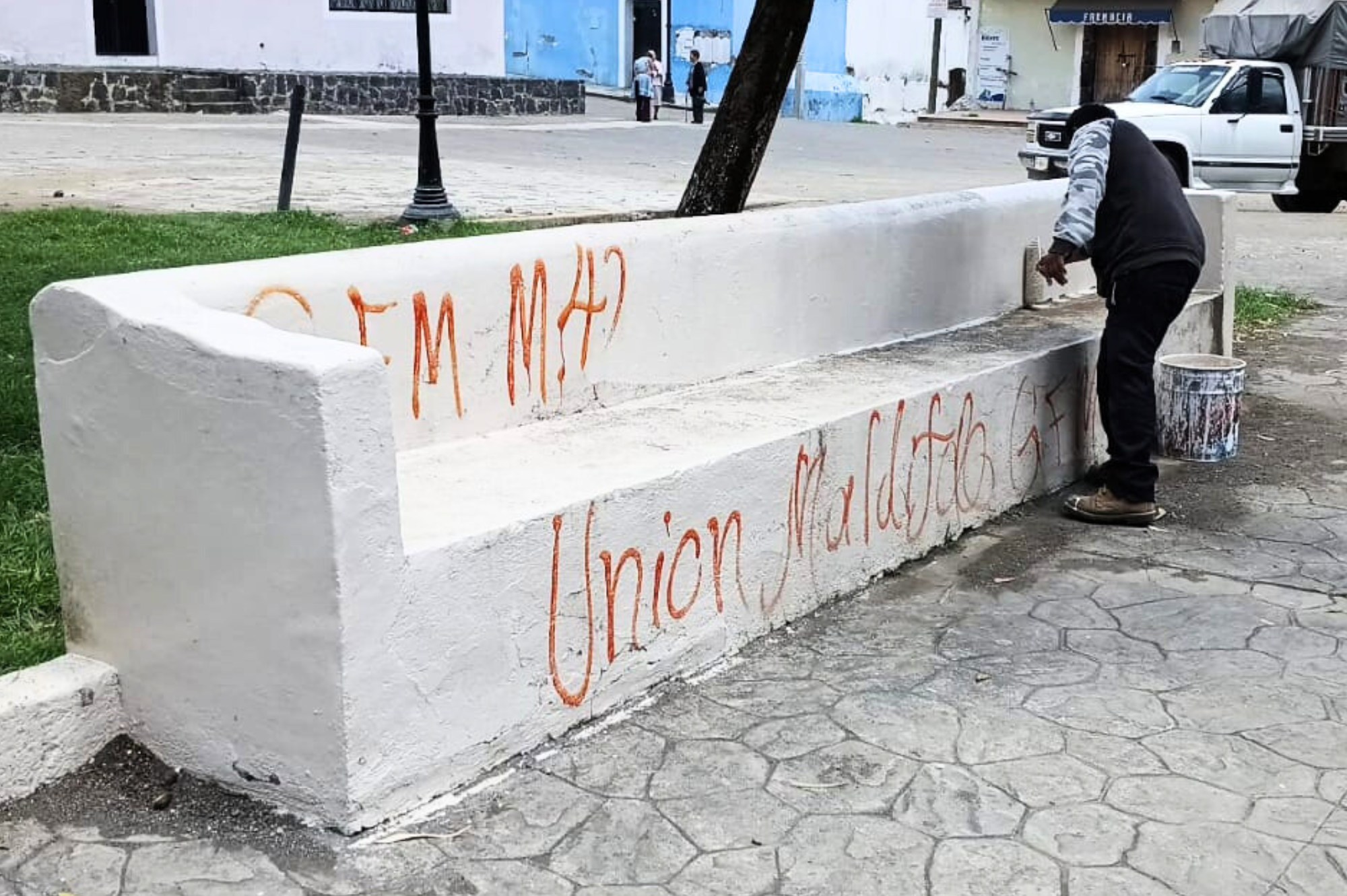 Un trabajador pinta de blanco una banca del zócalo de Tochimilco que había sido vandalizada con grafitis, como parte de las labores de mantenimiento y rehabilitación emprendidas por el Ayuntamiento.