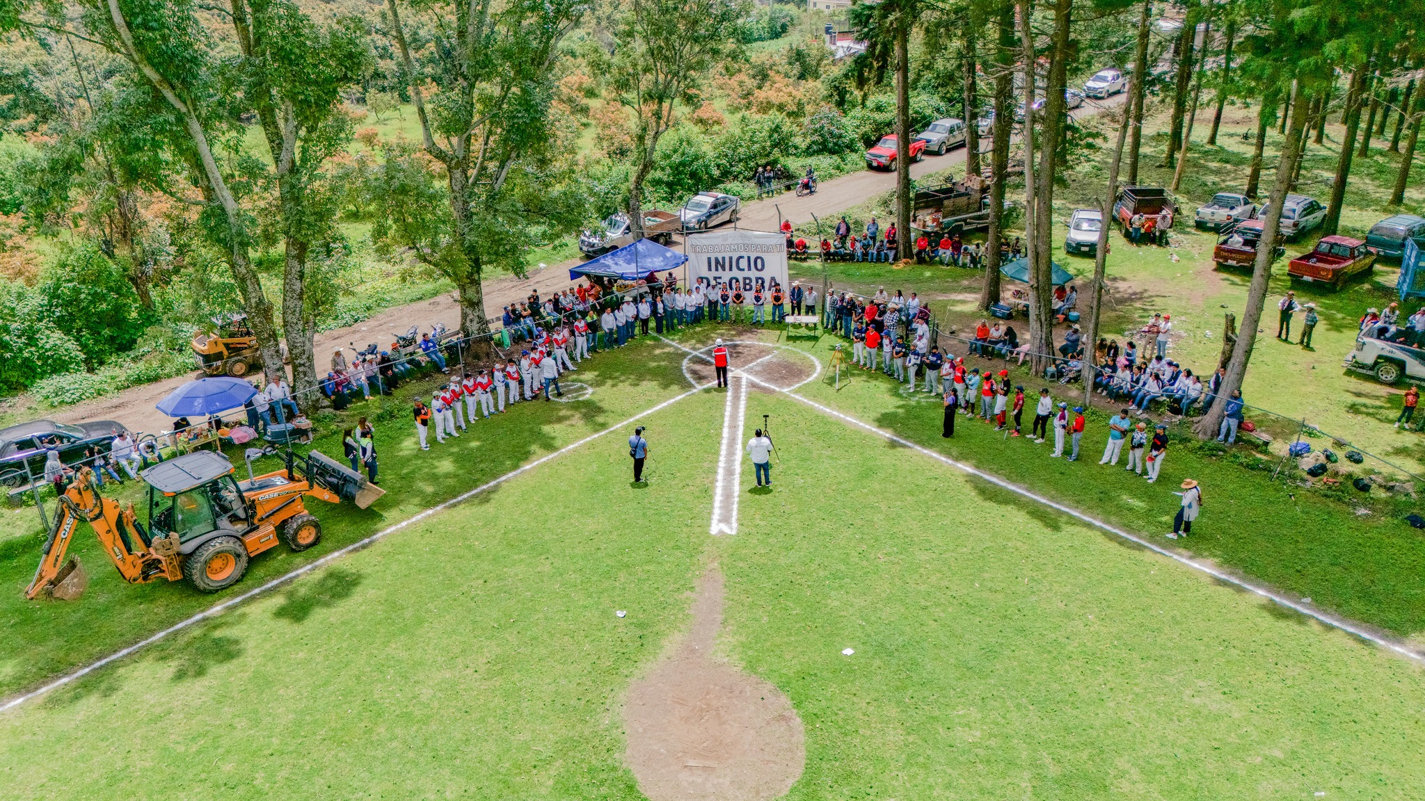 Vista aérea de un campo de béisbol en Santa Catalina Cuilotepec, donde autoridades municipales, equipos deportivos y comunidad se reúnen en torno a un acto protocolario para dar inicio a la construcción de un espacio público multideportivo.