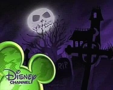 Pantalla de Disney Channel con temática de Halloween, mostrando una luna con rostro tenebroso, árboles secos, lápidas y una casa embrujada, parte de los especiales Abracadubre y Monstubre.