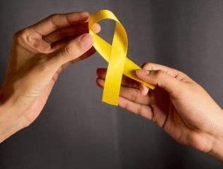 Dos manos sostienen un lazo amarillo, símbolo de esperanza y apoyo en la prevención del suicidio.