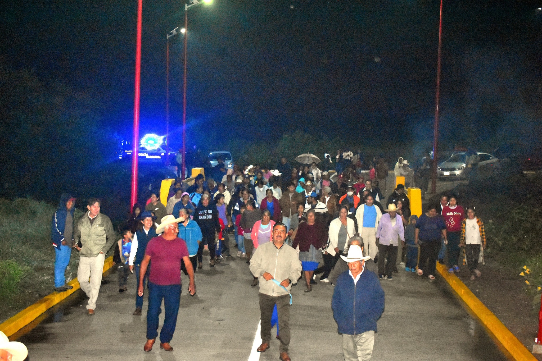 Habitantes de Cacaloxuchitl recorren las nuevas calles de concreto hidráulico durante la inauguración nocturna organizada por el Ayuntamiento de Huaquechula.