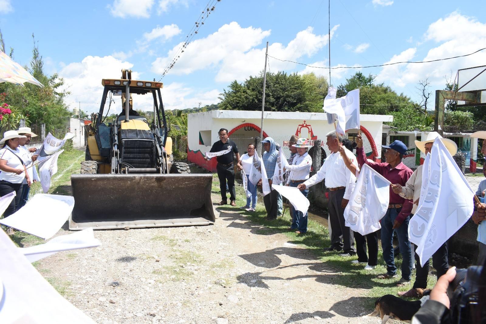 Un grupo de autoridades y ciudadanos realiza el banderazo de inicio de obra en la calle Melchor Ocampo, comunidad de Huejotal, acompañados de maquinaria pesada lista para comenzar los trabajos de adoquinamiento.