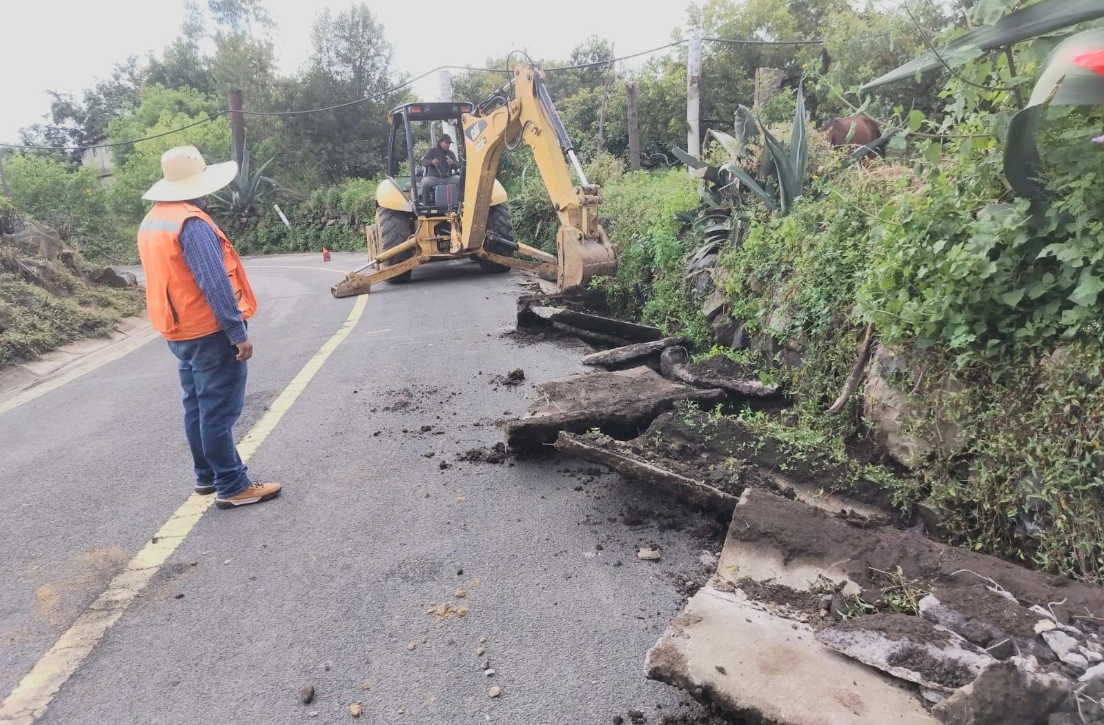 Personal de obras públicas del Ayuntamiento de Tochimilco supervisa la rehabilitación de la red de drenaje sanitario en la junta auxiliar de Santa Catarina Tepanapa, utilizando maquinaria pesada para retirar tuberías dañadas y mejorar la infraestructura urbana.