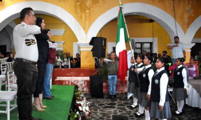 Autoridades municipales de Huaquechula participan en un acto cívico junto a estudiantes, reafirmando los valores patrios y el compromiso con la educación y la identidad nacional.