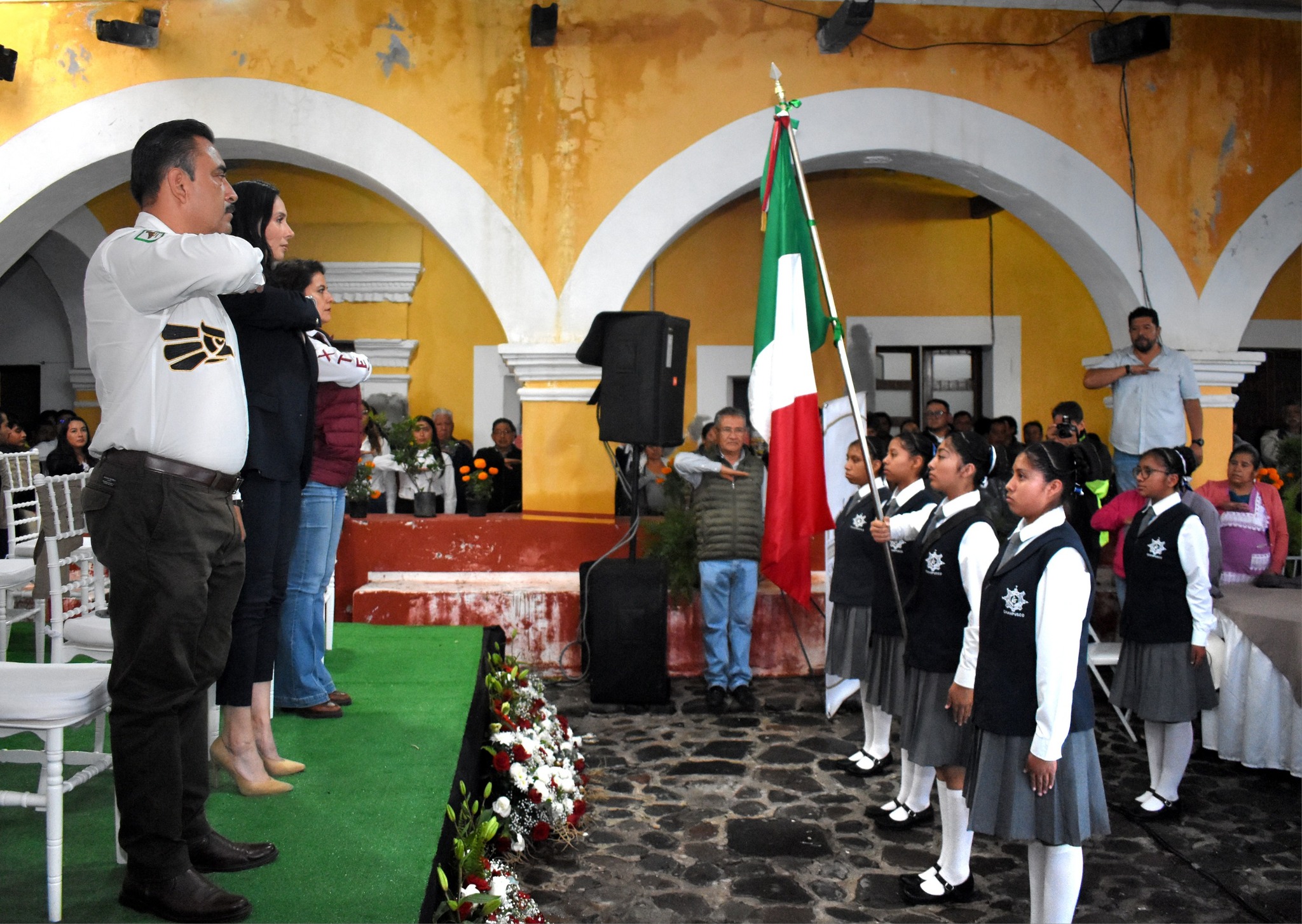 Autoridades municipales de Huaquechula participan en un acto cívico junto a estudiantes, reafirmando los valores patrios y el compromiso con la educación y la identidad nacional.