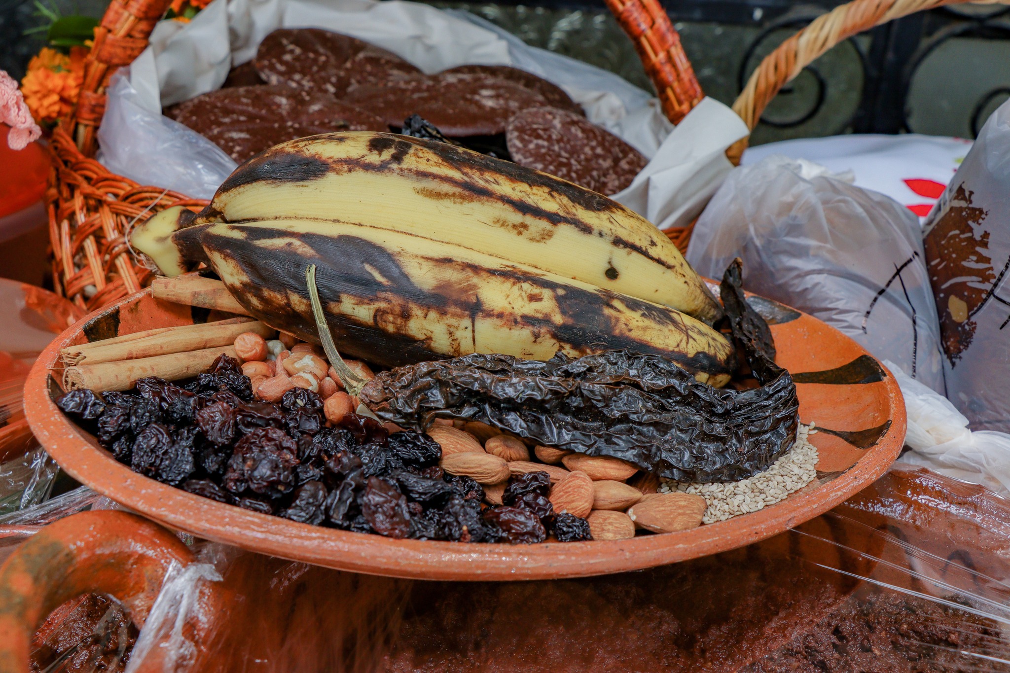 Ingredientes tradicionales del mole poblano, como plátano macho, almendras, chiles secos, pasas y canela, utilizados en los talleres “Encendiendo las Tradiciones” en Tochimilco.