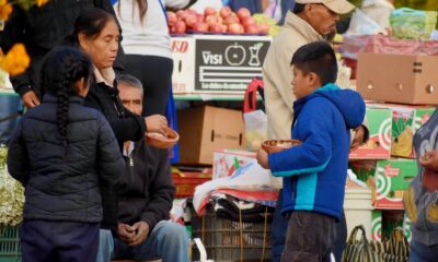 Mujer y niños participan en el tradicional Trueque de Huaquechula, intercambiando productos del campo en la Plaza Grande antes del Día de Muertos.