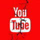Logo de YouTube agrietado sobre fondo rojo, representando la caída mundial de la plataforma y las fallas reportadas en su servicio.