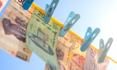 Fotografía de billetes mexicanos colgados con pinzas en un tendedero, representando las nuevas familias de billetes emitidas por el Banco de México.