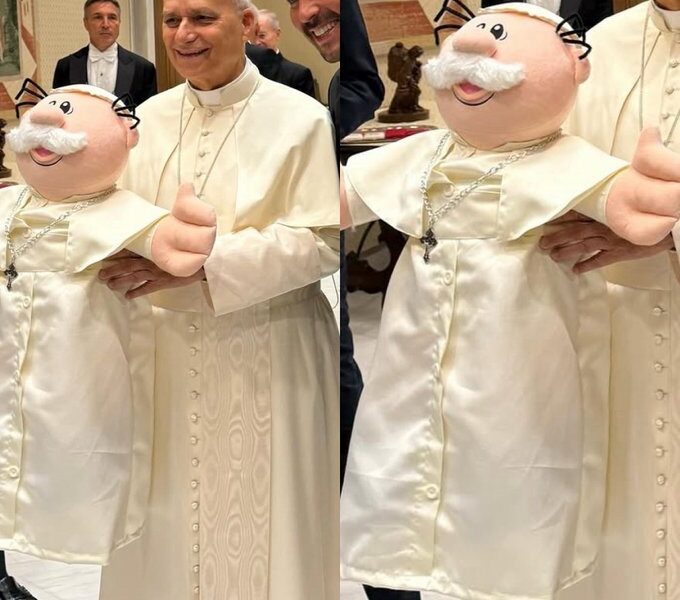 Líder religioso posa con un muñeco vestido de papa durante un encuentro oficial, imagen que generó debate sobre simbolismo religioso y comunicación institucional.