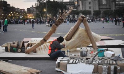 Estructura monumental en forma de esqueleto siendo instalada en el Zócalo de la Ciudad de México como parte de la Ofrenda Monumental del Día de Muertos.