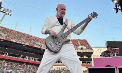 Sam Rivers, bajista de Limp Bizkit, tocando en vivo con su bajo en un estadio lleno de público durante una presentación de la banda.