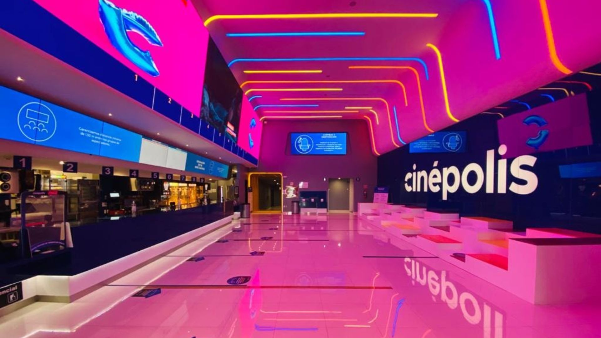 Interior de una sala de Cinépolis iluminada con luces de neón en colores rosa, azul y amarillo, representando la promoción de boletos a 29 pesos.