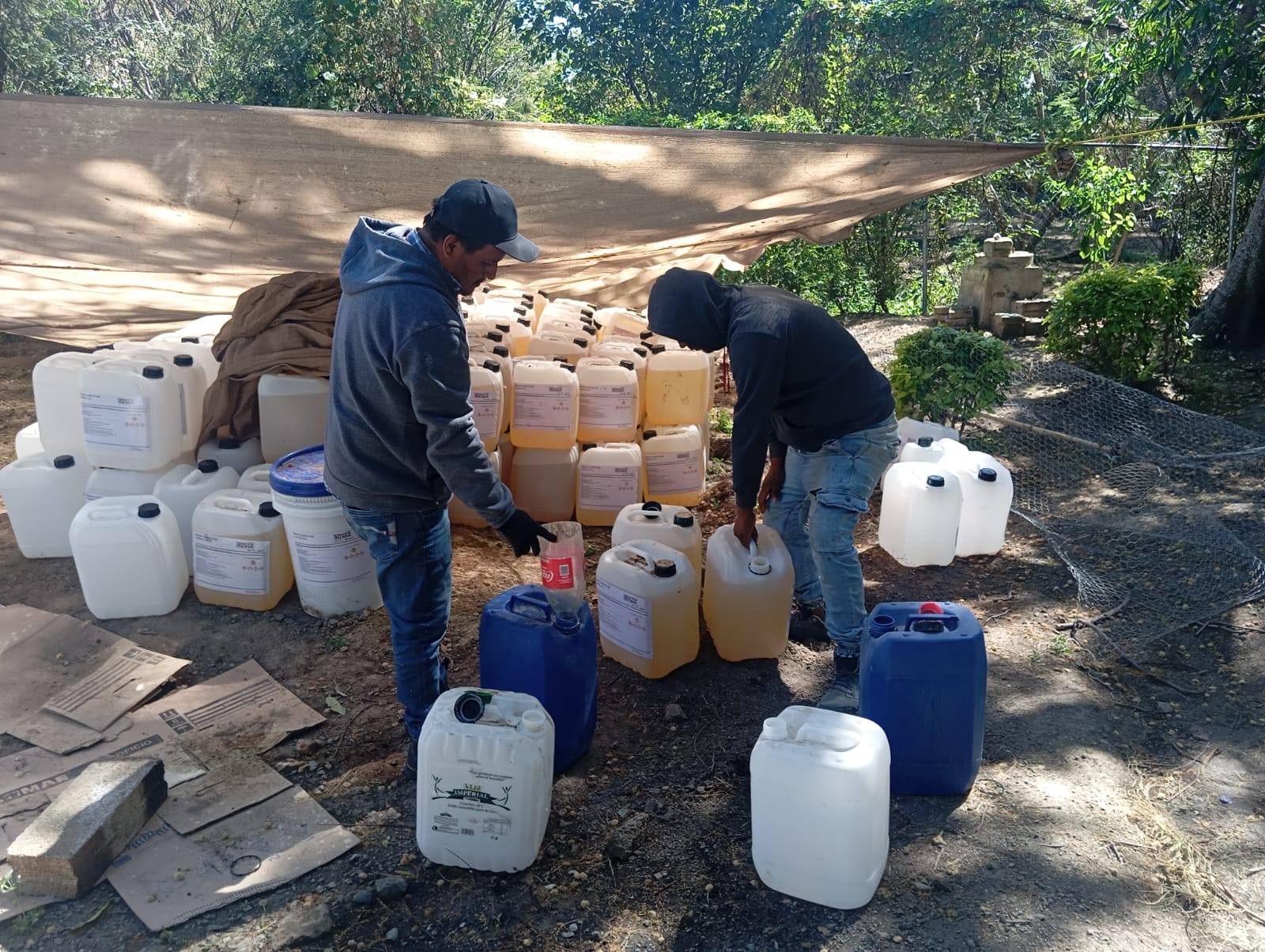 Personal de comunidades de Huaquechula carga bidones de cloro entregados por el Ayuntamiento para el tratamiento de agua potable.