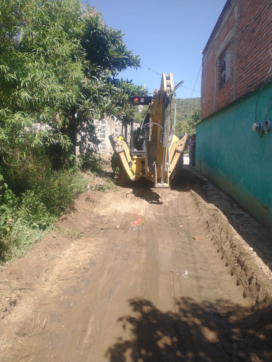 Retroexcavadora rehabilitando una calle afectada por lluvias en la cabecera municipal de Tochimilco.