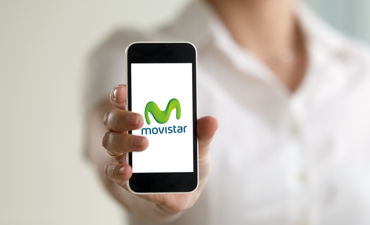 Teléfono móvil mostrando el logotipo de Movistar sobre fondo azul, ilustrando la salida de Telefónica de México.