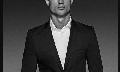 Retrato en blanco y negro de Cristiano Ronaldo vistiendo traje, mirando al frente con expresión seria y fondo oscuro.