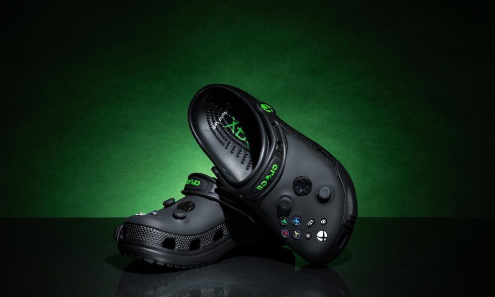 Crocs color negro edición especial inspirados en Xbox, con botones y diseño similar al control de la consola, sobre fondo verde oscuro.