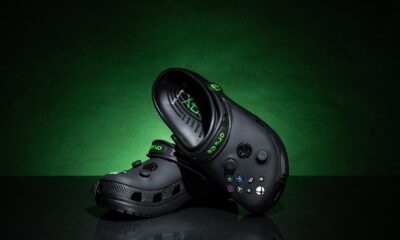 Crocs color negro edición especial inspirados en Xbox, con botones y diseño similar al control de la consola, sobre fondo verde oscuro.
