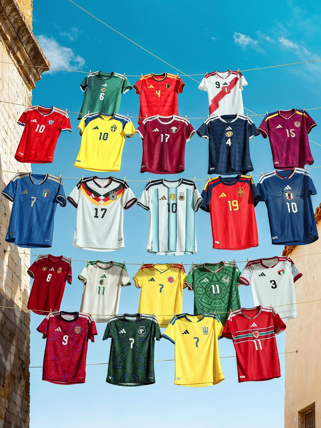 Camisetas oficiales Adidas de distintas selecciones nacionales colgadas bajo el sol, representando la colección rumbo al Mundial 2026.