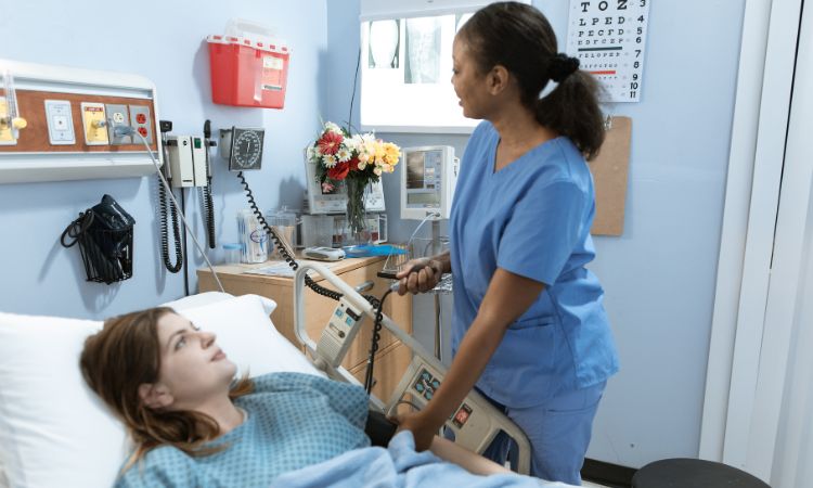 Enfermera atendiendo a una paciente joven en una cama de hospital, sosteniendo una barra de control médico en una habitación equipada.