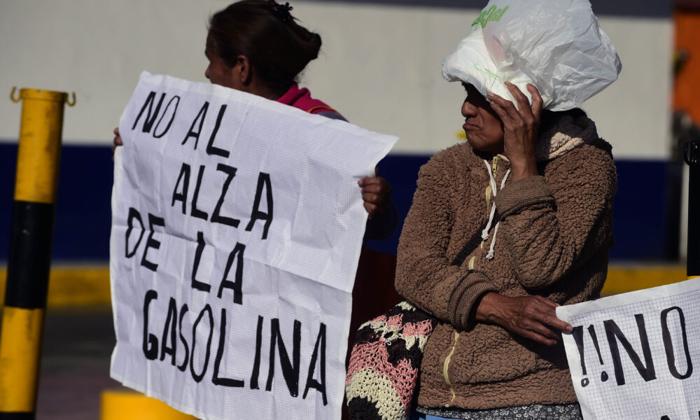 Dos mujeres protestan sosteniendo carteles con la frase “No al alza de la gasolina” durante una manifestación ciudadana en México.