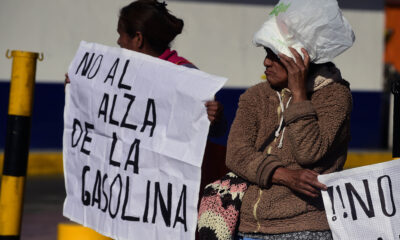Dos mujeres protestan sosteniendo carteles con la frase “No al alza de la gasolina” durante una manifestación ciudadana en México.