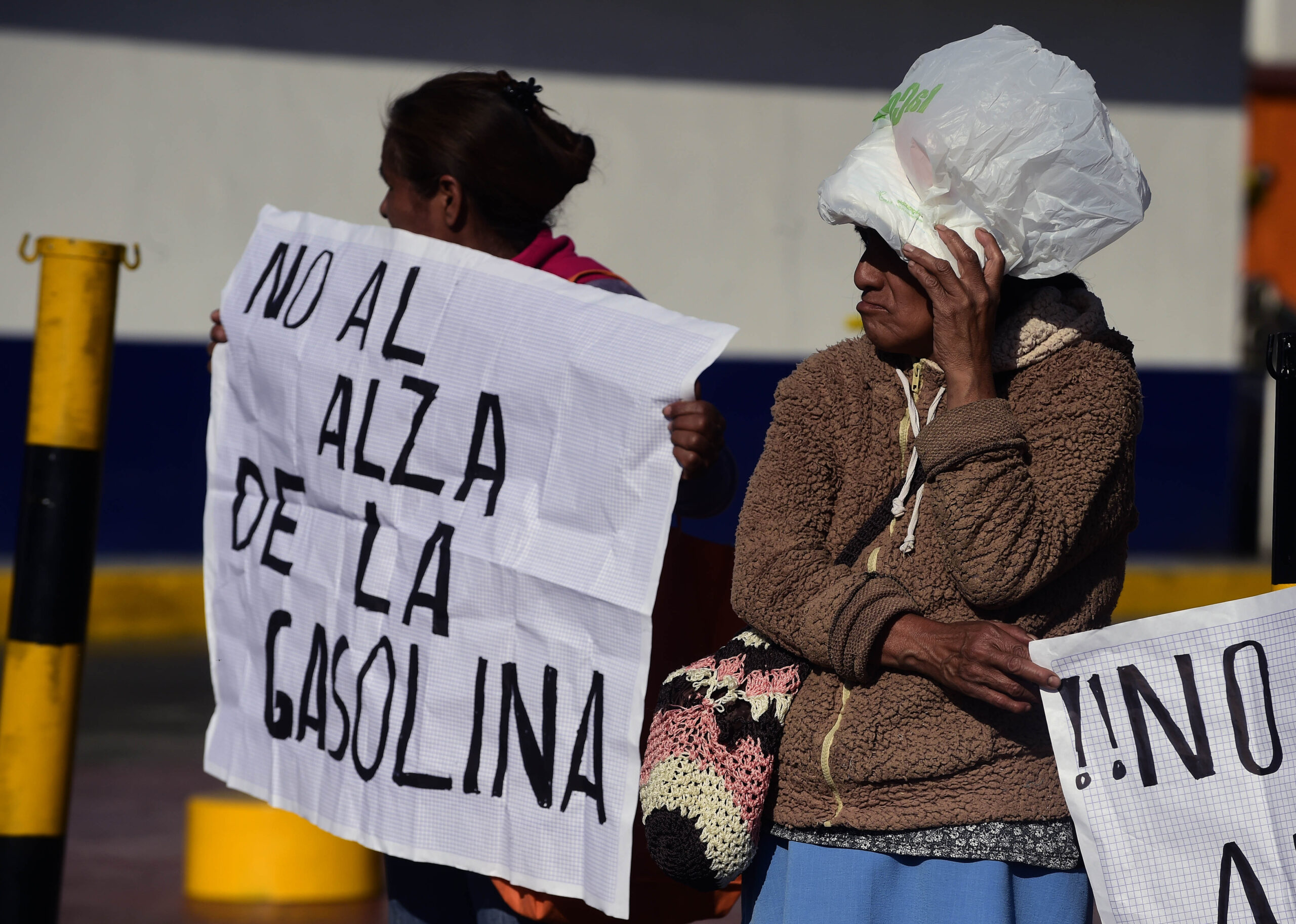 Dos mujeres protestan sosteniendo carteles con la frase “No al alza de la gasolina” durante una manifestación ciudadana en México.