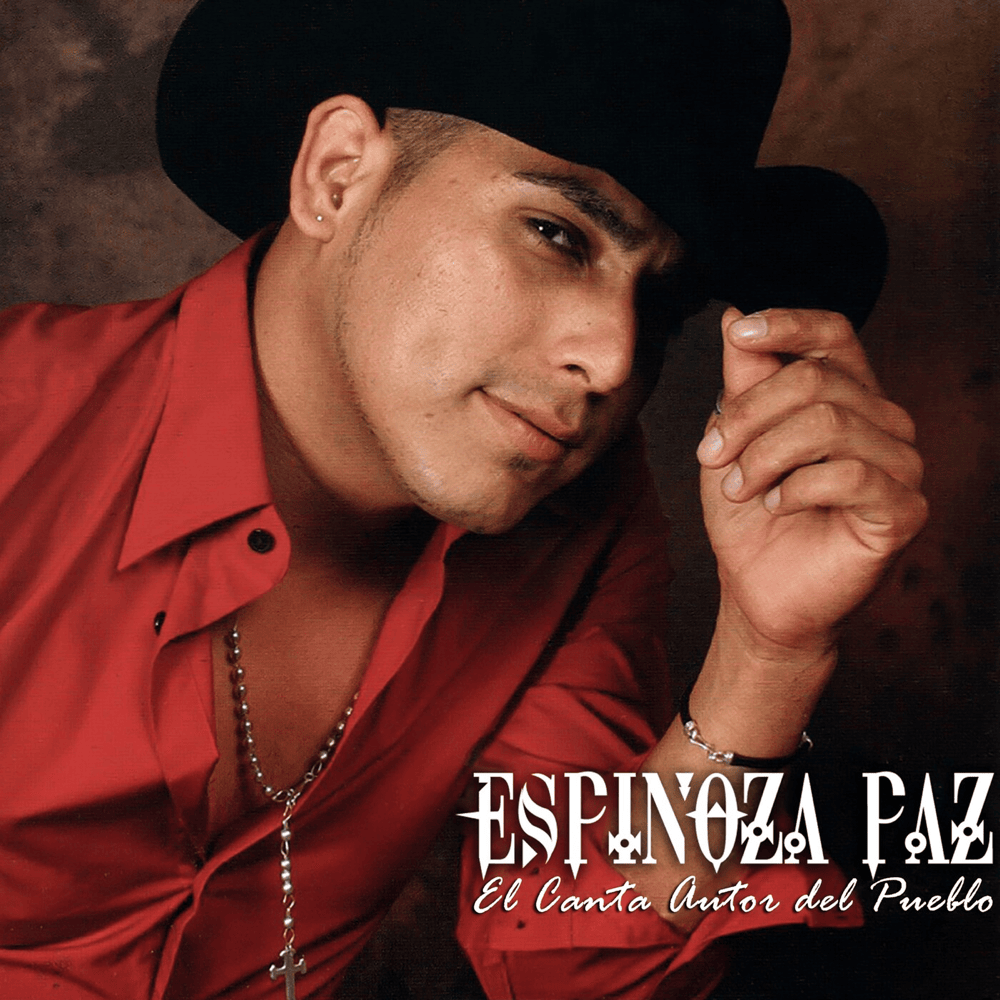 Fotografía de un hombre de sombrero negro y camisa roja, posando con la mano sobre el ala del sombrero.
