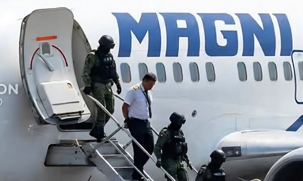Elementos de seguridad escoltan a una persona fuera de un avión en el Aeropuerto Internacional de la Ciudad de México.