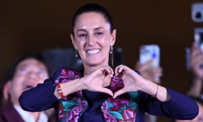 Claudia Sheinbaum en evento oficial con bandera de México