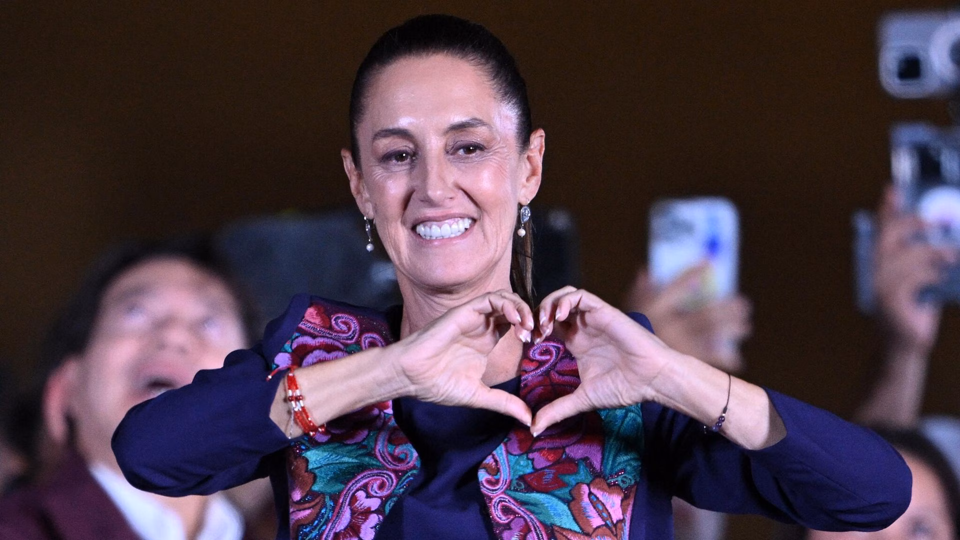 Claudia Sheinbaum en evento oficial con bandera de México