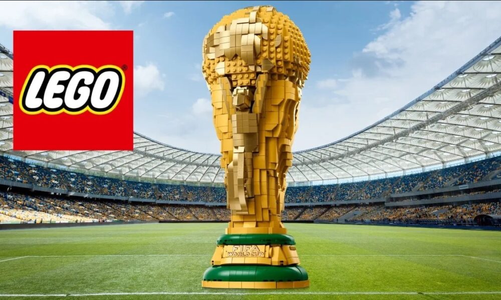 Trofelo de la Copa del Mundo construido con piezas LEGO en un estadio, acompañado del logo oficial de LEGO.