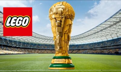 Trofelo de la Copa del Mundo construido con piezas LEGO en un estadio, acompañado del logo oficial de LEGO.