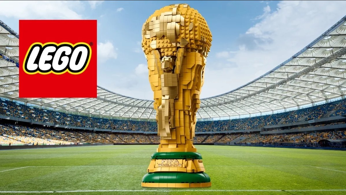 Trofelo de la Copa del Mundo construido con piezas LEGO en un estadio, acompañado del logo oficial de LEGO.