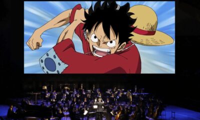 Escena de One Piece proyectada sobre escenario de una orquesta sinfónica durante un concierto.