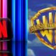 Logotipos de Netflix y Warner Bros enfrentados simbolizando una posible adquisición histórica en la industria del entretenimiento.