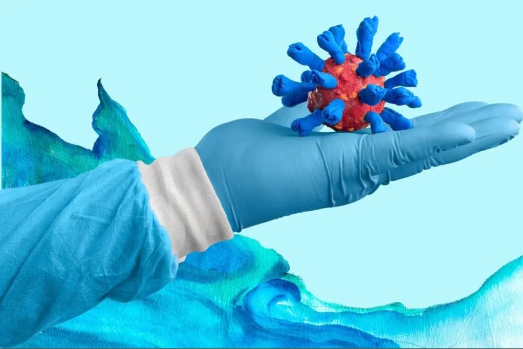 Representación del virus de la influenza sostenido por una mano con guante médico.