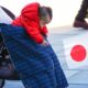 Bebé en Japón sosteniendo una bandera nacional, símbolo de la crisis de natalidad del país.