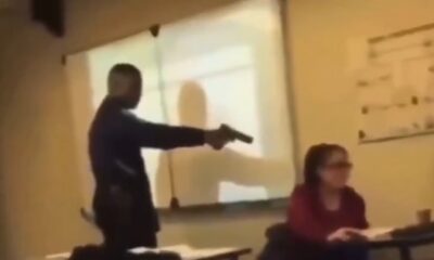 Estudiante amenaza a docente con un arma dentro de un salón de clases mientras otros observan.
