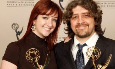 Craig McCracken y Lauren Faust sosteniendo premios Emmy en una ceremonia de televisión.