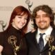 Craig McCracken y Lauren Faust sosteniendo premios Emmy en una ceremonia de televisión.