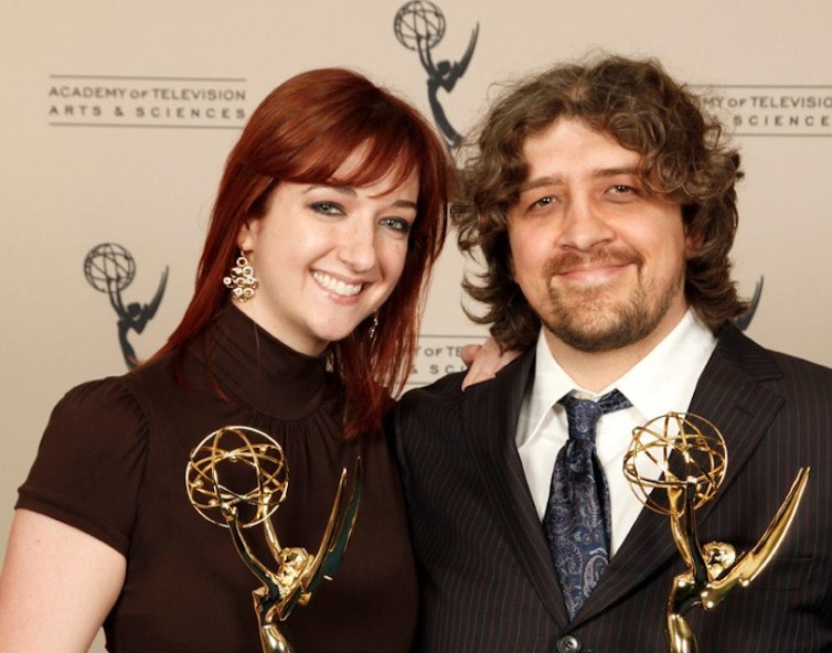 Craig McCracken y Lauren Faust sosteniendo premios Emmy en una ceremonia de televisión.