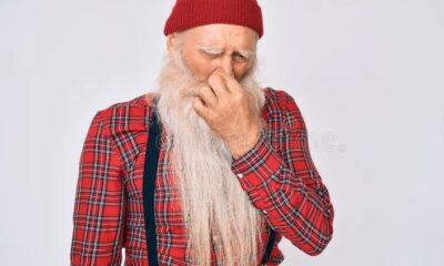 Hombre mayor tapándose la nariz mientras percibe un olor desagradable.