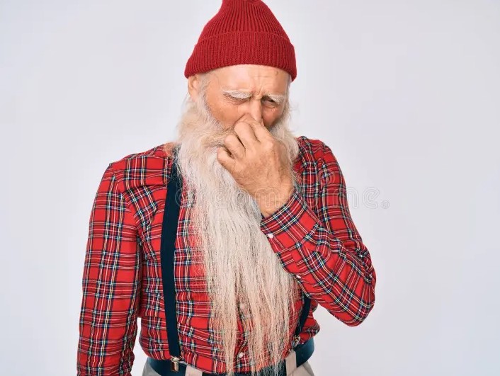 Hombre mayor tapándose la nariz mientras percibe un olor desagradable.