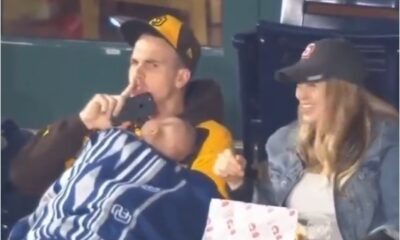 Padre sostiene a su bebé dormido en un estadio y pide silencio al público.