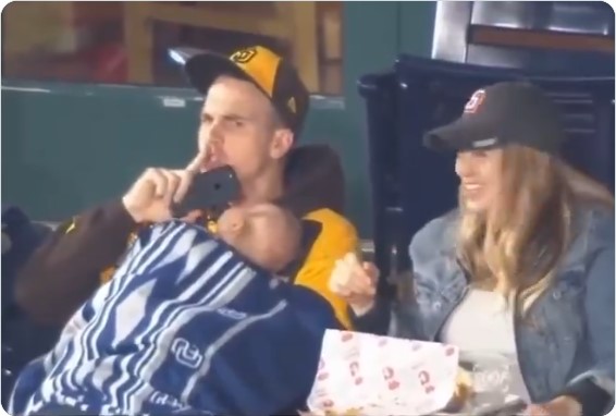 Padre sostiene a su bebé dormido en un estadio y pide silencio al público.