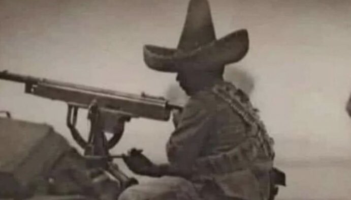 Soldado revolucionario operando una ametralladora, posiblemente durante la Revolución Mexicana.